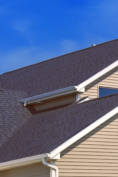 An angle view of the roof of a beige house, for information on Raleigh roofing company, Thurston Roof